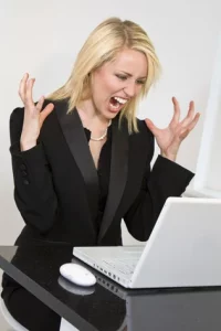 Frustrated woman yelling at laptop